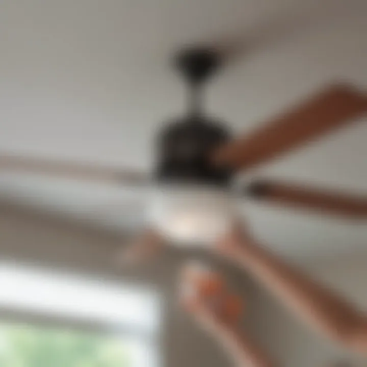 Person using a microfiber cloth to clean a ceiling fan